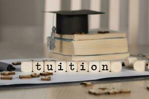 Word TUITION composed of wooden dices. photo