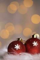 Red blazing Christmas balls on white artificial fur. Extreme closeup. photo