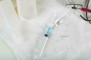 Syringe, alcohol wipe and glass ampule with antibiotics on a white napkin.Top view photo