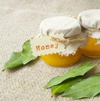 A glass of honey and bay leaves photo