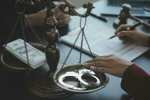 Justice and law concept.Male judge in a courtroom with the gavel, working with, computer and docking keyboard, eyeglasses, on table in morning light photo