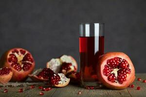 Glass of pomegranate juice on a wooden surface. photo