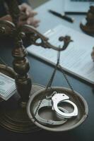 Justice and law concept.Male judge in a courtroom with the gavel, working with, computer and docking keyboard, eyeglasses, on table in morning light photo