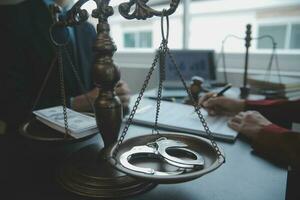 Justice and law concept.Male judge in a courtroom with the gavel, working with, computer and docking keyboard, eyeglasses, on table in morning light photo