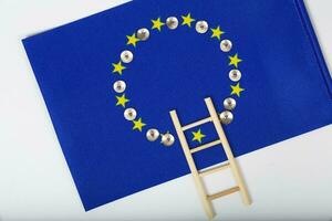 Ladder and pins on an European flag. Closeup photo