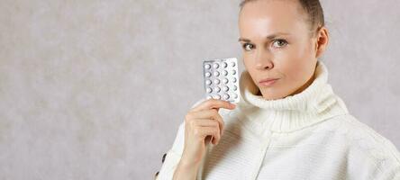 Young caucasian lady  dressed in a knitted sweater with medication. Closeup photo