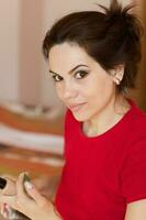 Young lady is applying make up on her face. Closeup photo