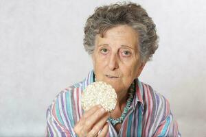 Old woman is eating dried bread photo