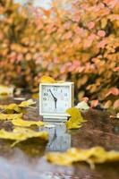 Old square alarm clock on a marble stone covered by rain. photo