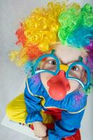 Boy of five years dressed in the costume of a clown and funny eyeglasses with red nose. photo