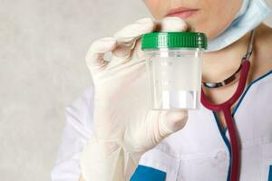 A collection cup for urine test. Closeup photo