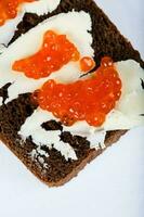 cereal negro un pan con mantequilla y rojo caviar. foto