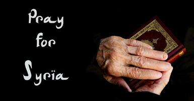 The hands of senior woman on the Koran photo