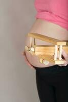 Young pregnant woman keeps wooden made airplane. photo