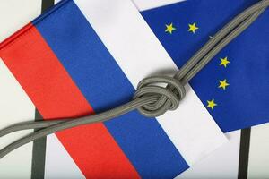 Two flags of EU and Russia,rope with a knot. Background photo