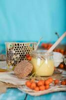 Rowan berries, glass with honey and honeycomb on a sackcloth. . photo