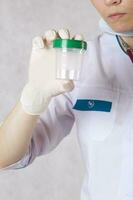 A collection cup for urine test. Closeup photo