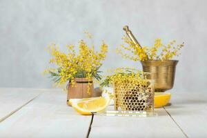 Mimosa flowers, honeycomb,two pieces of lemon photo