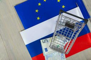 Shopping cart on European and Russian flags photo