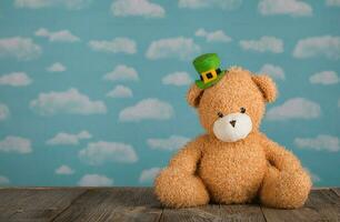 Brown plush teddy bear in a leprechaun hat on a wooden surface. photo