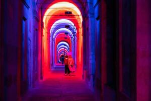 Bologna,Italy- June 23, 2023-People stroll at night under the arcades leading to the sanctuary of San Luca illuminated for the first edition of the Bologna arcades Festival. photo