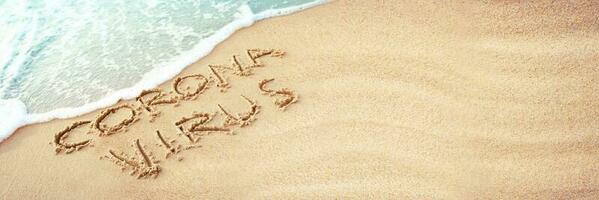 Corona virus written in the sand on vacation photo