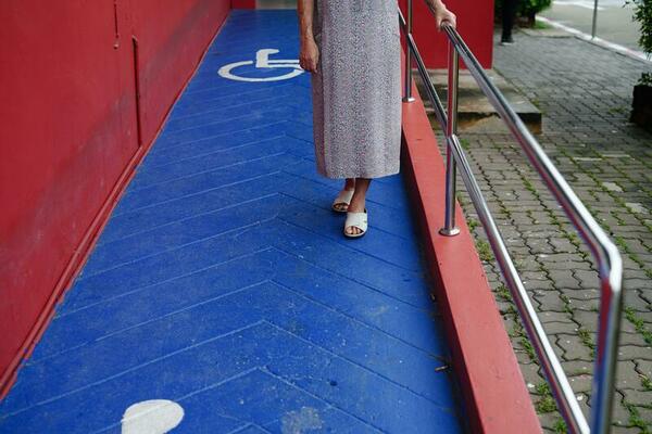 Asian elderly old woman patient use support rail on ramp, handrail safety grab bar, security in nursing hospital.