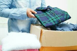 Clothes donations in cardboard box for volunteer. photo