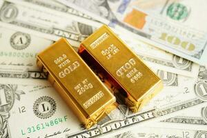 Gold bars on US dollar banknote money, finance trading investment business currency concept. photo