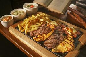 Beautiful barbecue board on a wooden table. In the background old books photo