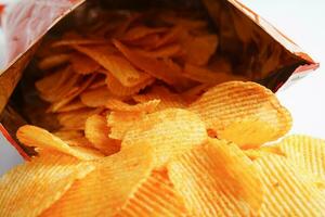 Potato chips in open bag, delicious BBQ seasoning spicy for crips, thin slice deep fried snack fast food. photo