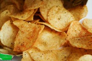 papas fritas en bolsa abierta, delicioso condimento de barbacoa picante para crips, refrigerio frito en rodajas finas comida rápida en bolsa abierta. foto