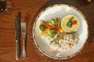 Beautiful dish of salmon in white sauce with vegetables and puree. photo