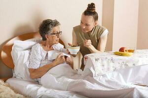 Visit of senior social work assistant to an old woman photo