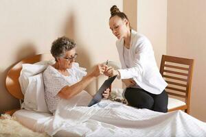 Visit of senior social work assistant to an old woman photo