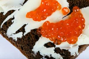 Cereal black bread with butter and red caviar. photo