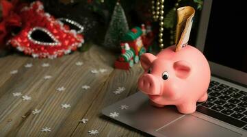 Pink piggy bank with banknote on a laptop. photo