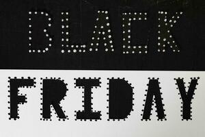 Words BLACK FRIDAY are cut out from black carton paper. photo