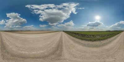 360 hdri panorama on gravel road with clouds and sun on blue sky in equirectangular spherical  seamless projection, use as sky replacement in drone panoramas, game development sky dome or VR content photo