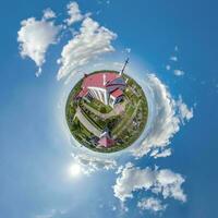 little planet transformation of spherical panorama 360 degrees overlooking church in center of globe in blue sky. Spherical abstract aerial view with curvature of space. photo