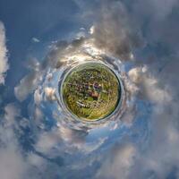 tiny planet in sky with clouds overlooking old town, urban development, historic buildings and crossroads. Transformation of spherical 360 panorama in abstract aerial view. photo