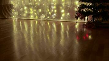 Christmas ornaments and light reflected on the floor in a dark room at christmas eve video