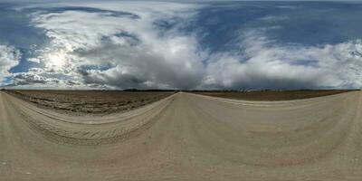 spherical 360 hdri panorama on gravel road with overcast sky before storm in equirectangular seamless projection, use as sky replacement in drone panoramas, game development as sky dome or VR content photo