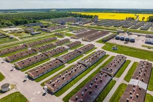 aerial panoramic view over livestock farm and agro-industrial complex with silos and rows of barns, pigsties, chicken coops photo