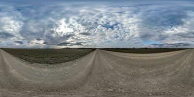 gravel road with clouds on overcast sky as spherical 360 hdri panorama in equirectangular seamless projection, use as sky replacement in drone panoramas, game development as sky dome or VR content photo