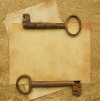 Two old rusted keys on an old surface. photo