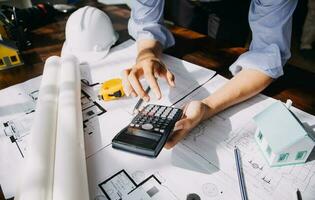 architect man working with laptop and blueprints,engineer inspection in workplace for architectural plan,sketching a construction project ,selective focus,Business concept vintage color photo