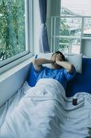 young injured man in hospital room sitting alone in pain looking negative and worried for his bad health condition sitting on chair suffering depression on a sad lonely medical background photo