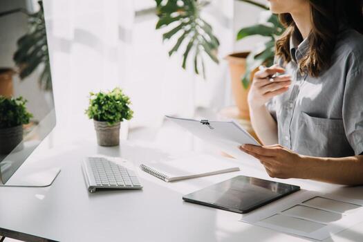 Moda diseñador l joven asiático mujer trabajando utilizando computadora portátil, tableta y sonriente mientras en pie en taller respondiendo en negocio foto