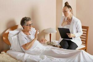 Visit of senior social work assistant to an old woman photo